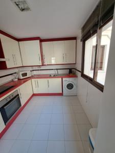 a kitchen with white cabinets and a washing machine at Atico TERRAZA DEL CARMEN in Salobreña