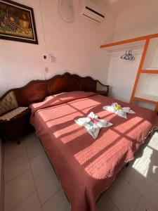 ein Schlafzimmer mit einem Bett mit zwei Handtüchern darauf in der Unterkunft Hotel Bello Caribe in Cozumel