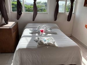 een slaapkamer met een bed met handdoeken erop bij Hotel Bello Caribe in Cozumel