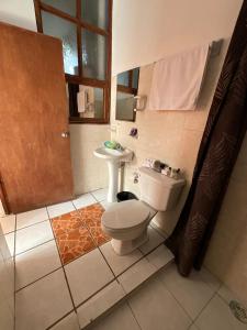 a bathroom with a toilet and a sink at Hotel Bello Caribe in Cozumel