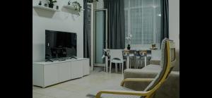 un soggiorno con TV e tavolo con sedie di Monti Exclusive Apartment a Roma