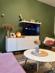 a living room with a tv and a table at Apartman Aurora in Zvezdara