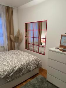 a bedroom with a bed and a mirror on the wall at Apartman Aurora in Zvezdara
