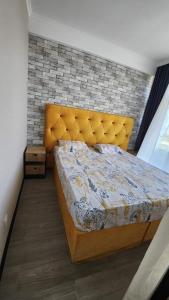 1 dormitorio con 1 cama extragrande y pared de ladrillo en Квартира в Гонио 85 м2, en Gonio