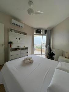1 dormitorio con 1 cama blanca grande y toallas. en Lindo apto Beira Mar na Barra, en Río de Janeiro