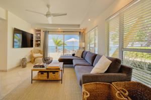 a living room with a couch and a view of the ocean at Incredible Beach Front Villa! in George Town
