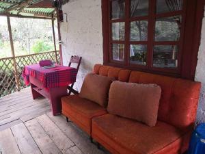 eine Couch auf einer Veranda mit einem Tisch in der Unterkunft Posada San Bartolomé in Sigsig