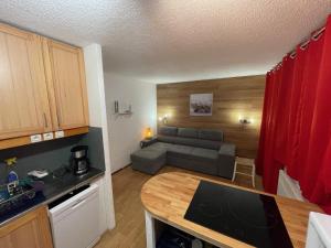 a kitchen and living room with a couch and a table at Appartement Plagnes Villages in La Plagne Tarentaise