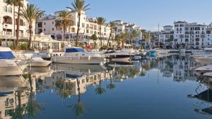un groupe de bateaux amarrés dans un port de plaisance comportant des bâtiments dans l'établissement Lovely Aldea Beach Apartment, à Manilva