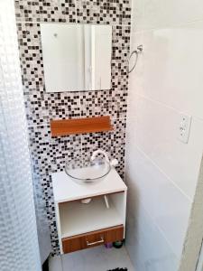 a bathroom with a sink and a mirror at Mini Casa Aconchegante in Saquarema