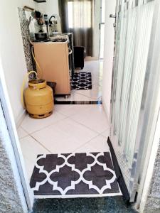 pasillo con cocina con alfombra en el suelo en Mini Casa Aconchegante, en Saquarema