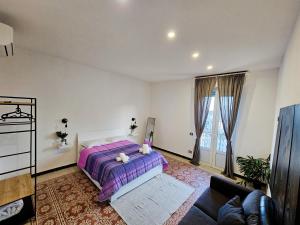 a bedroom with a purple bed and a couch at The view in La Spezia