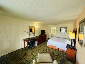 a hotel room with a bed and a desk at Boca Inn in Boca Raton