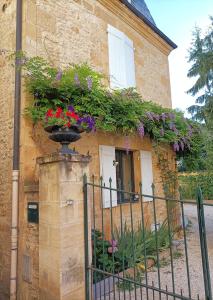 dom z kwiatami na boku w obiekcie Les Chambres d'Hotes chez Alisa et Daniel w mieście Sarlat-la-Canéda