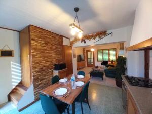 uma sala de estar com uma mesa de madeira e uma cozinha em Le chêne BuBu em Deville