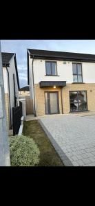 a brick house with a driveway in front of it at Home in Kilmuckridge in Wexford