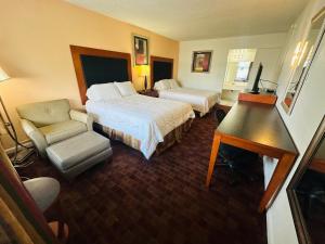 a hotel room with two beds and a desk at Boca Inn in Boca Raton