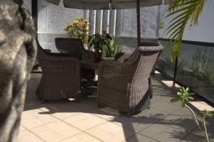 4 sillas de mimbre y una mesa en un patio en Casa Petunia Pousada Boutique, en Salvador