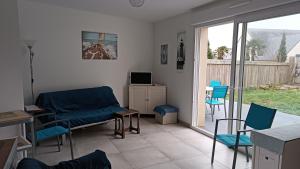 sala de estar con sofá, sillas y ventana en Grand studio lumineux près de la mer, en Locmariaquer