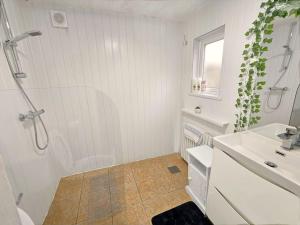 uma casa de banho branca com um chuveiro e um lavatório. em Heartlands House, BullRing, Blues Ground, NEC, BHX em Birmingham