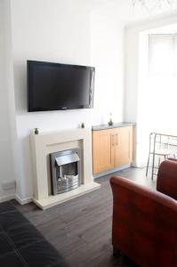 a living room with a fireplace with a flat screen tv above it at Heartlands House, BullRing, Blues Ground, NEC, BHX in Birmingham