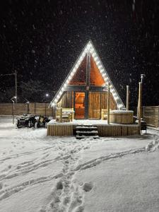 uma cabana de madeira na neve à noite em Borjomi Story em Borjomi