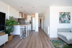 ein Wohnzimmer mit einem Sofa und einer Küche in der Unterkunft Castelldefels Beach&Fun in Castelldefels