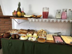 a table filled with different types of bread and pastries at Pousada Recanto da Giovana in Campos do Jordão
