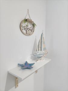 a white shelf with a toy sailboat on it at El sueño de Noctiluca in Rincón de la Victoria