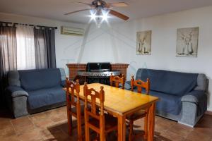 sala de estar con mesa, sillas y sofá en Villa Zapatilla, en Chiclana de la Frontera