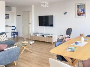 Una sala de estar con una mesa y un televisor. en SEA VIEW Classé 3 étoiles climatisé Terrasse Vue Mer Parking by LaConciergerie13, en La Ciotat