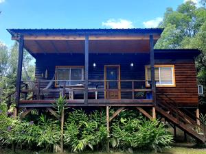 a log cabin with a porch and a deck at Delta tigre "Peperina Gambado" in Tigre