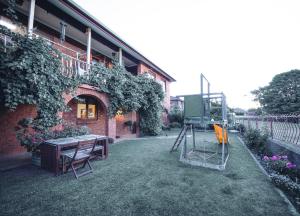a garden with a table and chairs in front of a building at Cooma Guest House in Cooma