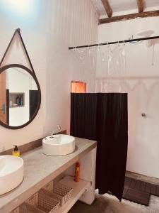 La salle de bains est pourvue de 2 lavabos et d'un miroir. dans l'établissement Casa Hibiscus - Caraíva/BA, à Porto Seguro