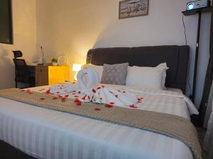 a bed with red rose petals on it at Cubic Botanical Studio 情侣体验民宿电影院的浪漫 in Kuala Lumpur