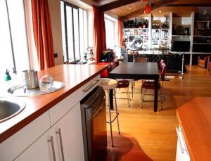une cuisine avec un comptoir et une salle à manger dans l'établissement Loft character with a view of court, à Paris