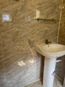 baño con lavabo y pared de mármol en Mph mini en Lagos