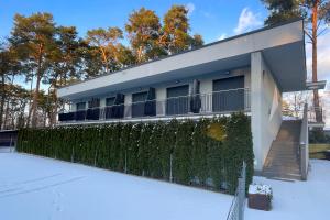 a house with a fence in the snow at Marina Boszkowo in Boszkowo-Letnisko