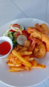 a plate of food with french fries and a salad at Bojang River Lodge in Bakau