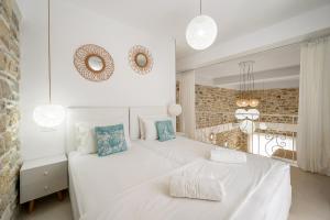 Un dormitorio blanco con una cama blanca y un espejo. en Aphrodites Luxury pearls 1, en Pitsidia 56 fotos más