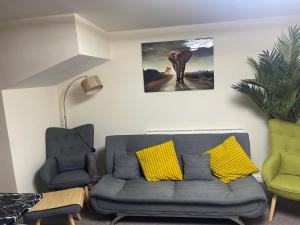sala de estar con sofá y 2 sillas en GM247 Nice Accommodation Stays, en Wigan
