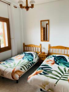 a bedroom with two beds and a mirror at CasasQuesada in Ciudad Quesada +11 photos