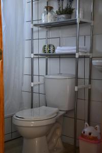 uma casa de banho com WC e uma prateleira com toalhas em Cabaña de campo em Valdivia