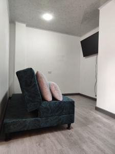 - un canapé vert avec des oreillers dans l'établissement Apartamento vía a termales, à Santa Rosa de Cabal