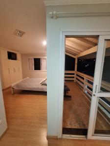 Schlafzimmer mit einem Bett und einer Glasschiebetür in der Unterkunft A casa Amarela in Atibaia