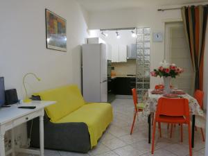 uma sala de estar com uma cadeira amarela e uma mesa em Thany casa em Grugliasco