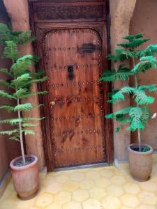 two potted trees in front of a wooden door at Atlas Haven in Imlil