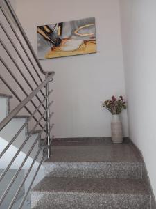 a staircase with a painting and a vase of flowers at On the river Imotski Baška Voda in Imotski