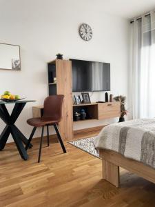 a bedroom with a desk and a table with a chair at APARTMAN 52 - Privatni parking za goste in Novi Sad
