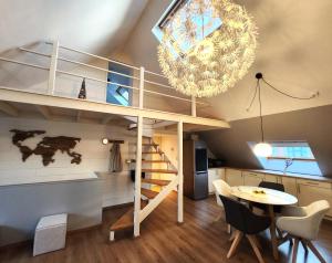 Habitación con cama elevada y comedor con mesa. en Appart4you, en Namur